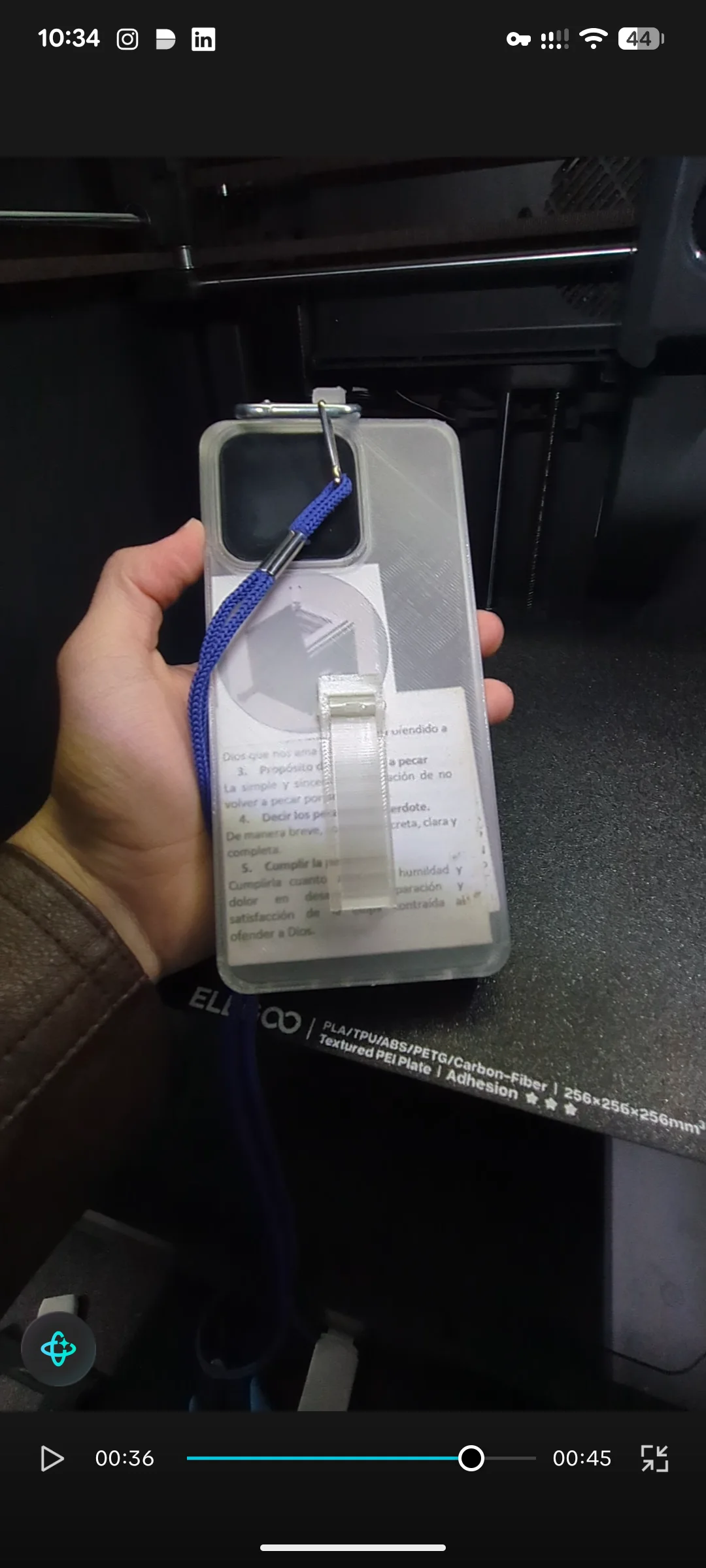 Manufactured translucent TPU phone case held in front of a 3D printer